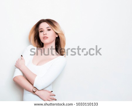 beautiful young blonde woman posing on grey background