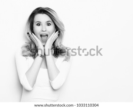beautiful young blonde woman posing on grey background
