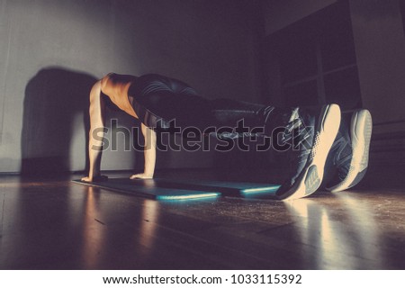 Plank as good abdomen exercise. Man exercising lying on the gym mat. from the side view