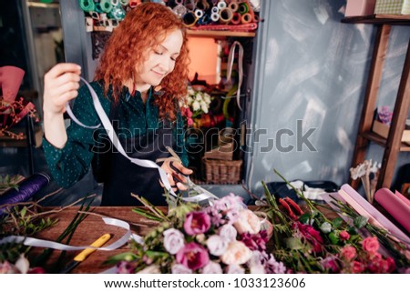 image of happy girl with red hair using ribbon to make compositions. working day