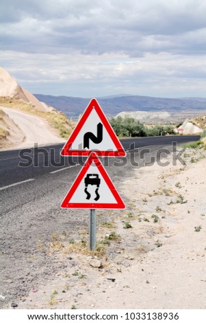 Warning traffic signs together, Slippery road surface and double bend, first to right