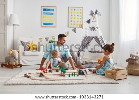 family father and children play a toy railway in the playroom
 Royalty-Free Stock Photo #1033143271