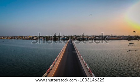 Aerial view of the road bridge over casamance river in Ziguinchor, Senegal, Africa during a sunset. Drone picture looking towards the city above the driving platform.