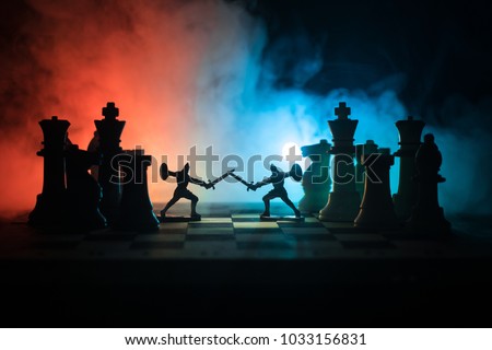 Medieval battle scene with cavalry and infantry on chessboard. Chess board game concept of business ideas and competition and strategy ideas Chess figures on a dark background with smoke and fog. Royalty-Free Stock Photo #1033156831