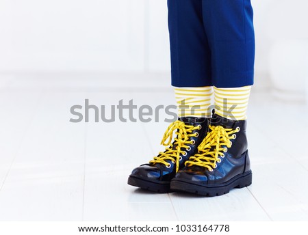 stylish look of patent leather ankle boots with yellow shoelaces and socks at young boy