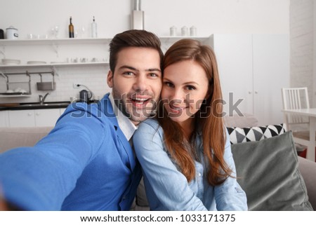 Young couple together at home weekend taking selfie photos cheerful