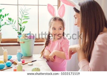 Mother and daughter together at home easter preparation in bunny ears playing rabbits