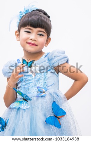 Cute Asian girl wearing a blue dress smiling happily with blue dress with butterfly on white background.
