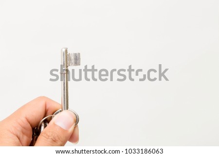 Hand holding the key Isolated on white background. Studio lighting.