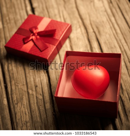 Red heart in  gift box on wooden plank. Concept for valentine day.
