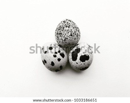 Black and white image of three quail eggs in white background