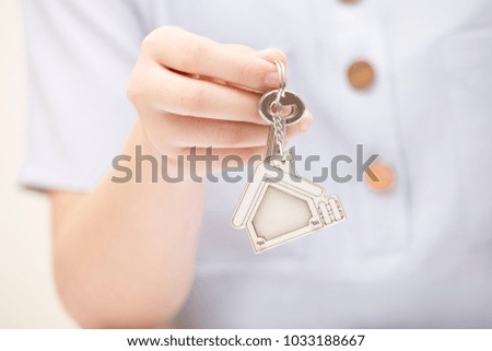 Woman hand holding home key. Concept for real estate business.