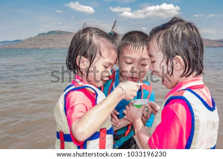 Blurred children playing in lake on summer on mountain and blue sky cloud background 