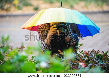 A Korean woman is taking a picture with an umbrella on the day of the rain.