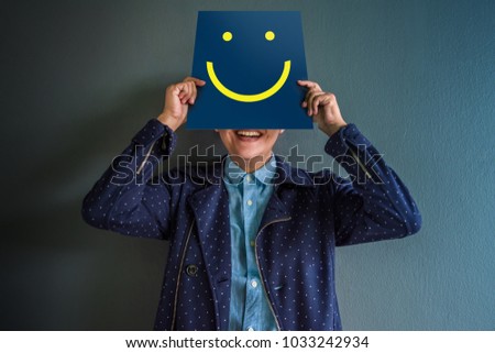 Customer Experience Concept, Portrait of Client with Smiling and holding Paper of Happy Smiley Face Cartoon Emotion