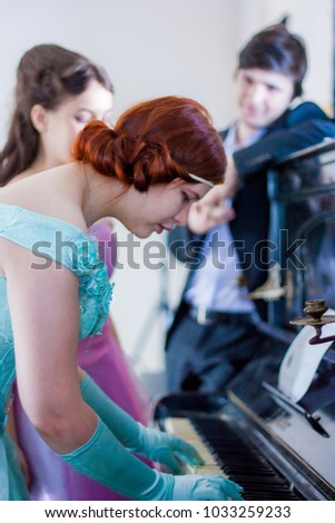 pianoforte. playing the piano. attractive lady in blue dress red-haired beauty
