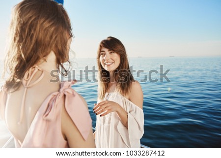 Two girls on yacht sailing in sea, having conversation about their great plans for vacation. Happy adult woman talks to her friend about plans for tomorrow. Maybe they should go to spa