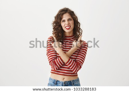 We will turn this party upside down. Attractive musician making horns-signs or rock gesture with crossed hands over chest, grimacing, being excited about future music contest she will take part in