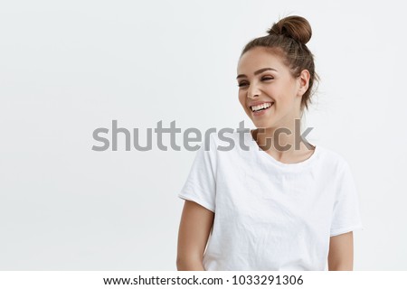 Portrait of emotive good-looking caucasian woman laughing while looking aside and standing against white background. Positive housewife on shopping with kids. Fashionable girl talks with friends Royalty-Free Stock Photo #1033291306