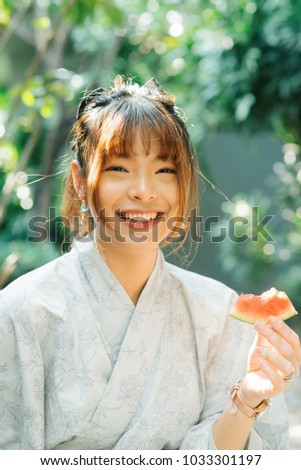 Lifestyle series: Asian woman in yukata eating slice of watermelon 