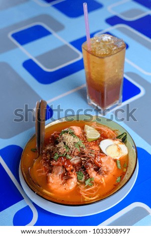 Prawn noodle or "Mee Udang" in the Malay language, is one of the traditional style food available in Penang. Pictured together with iced tea drink.