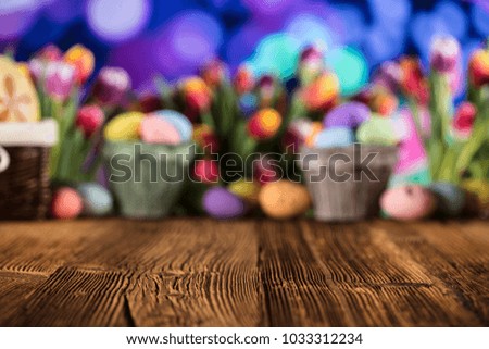Easter eggs. Colorful tulips. Rustic wooden table. Shallow depth of focus. Bokeh background. Place for typography. Easter theme.