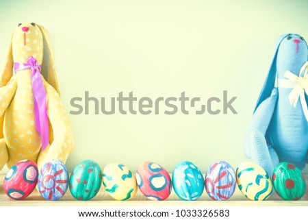 Easter bunny on a green background with Easter eggs. Handmade. Space for text. Rabbit Tilde. Toned image