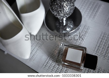 Wedding bride's elements such as shoes and perfume on the table on the striped background