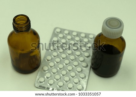 Prescription pill bottle spilling pills on to surface isolated on a white background
