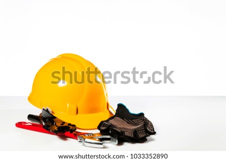 A set of hand tools and a helmet on a gray background.