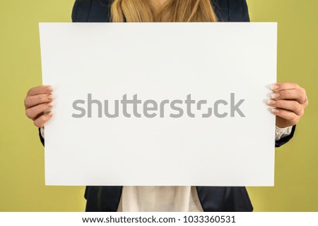 woman holding a blank billboard on green background