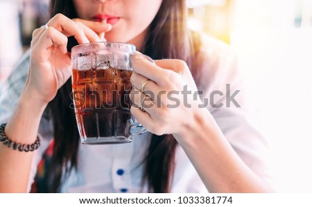 closeup woman drinking ice cola in the glass.food and beverage concept.  Royalty-Free Stock Photo #1033381774