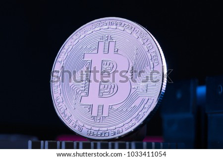 Close-up of bitcoin and processor on pink background