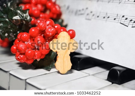 Christmas composition with wooden cross on piano, closeup