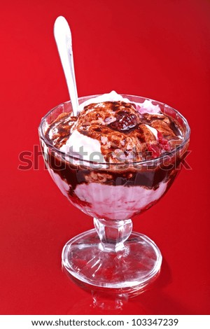 Ice cream with dressing in cup against red background