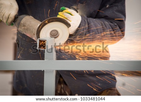 The worker cuts the metal with sparks