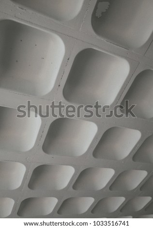 The molded concrete ceiling of a car park photographed in a vertical position to provided an abstract background