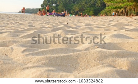 Sand on the beach with people and sunset background