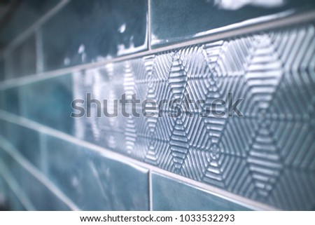Close-up of a glossy ceramic blue tile with a pattern