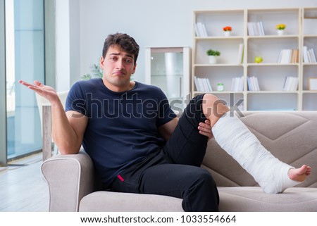 Man with broken leg recovering at home Royalty-Free Stock Photo #1033554664