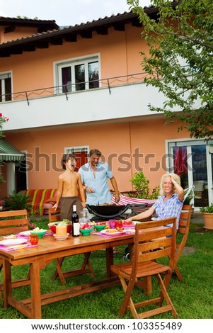 Family having a barbecue in the garden, eating
