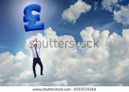 Businessman flying on british pound sign inflatable balloon