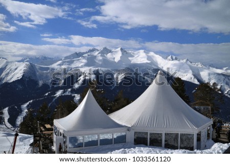 Tents cafe on the background of snowy mountain peaks.