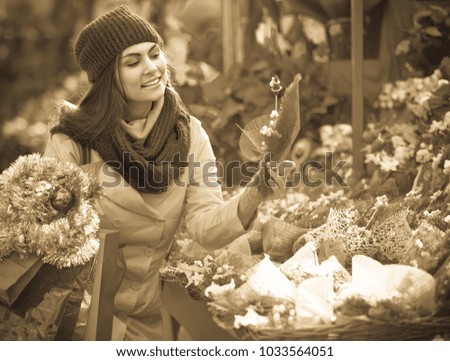 girl buying floral compositions at Christmas fair