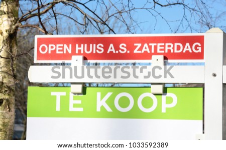A realtor sign with the text For Sale and this saturday open house in dutch