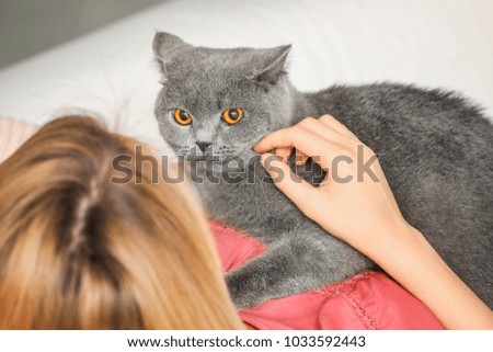 Young woman with cute pet cat at home