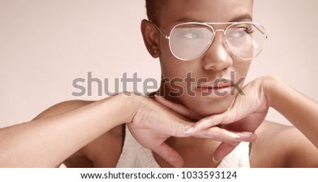 black woman with a short haircut in studio shoot closeup wearing glasses cobra