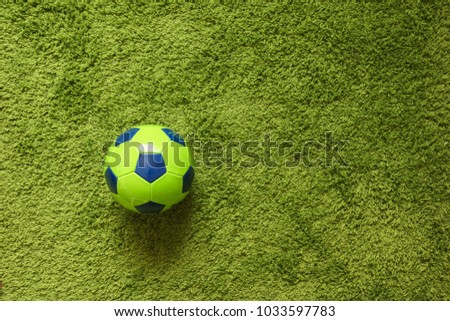 Football (Soccer) ball on a green surface imitating artificial grass. Sports photography