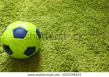 Football (Soccer) ball on a green surface imitating artificial grass. Sports photography