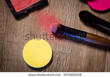 Brushes for make-up lie on a wooden table. Powder for make-up and brush are on the table. Set for make-up. Cosmetics.